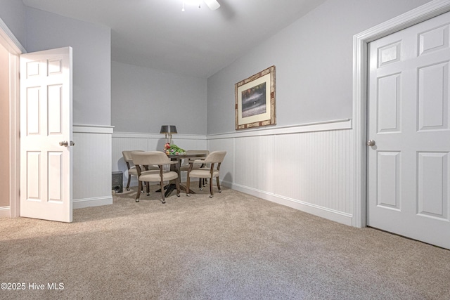 dining room featuring carpet and a wainscoted wall