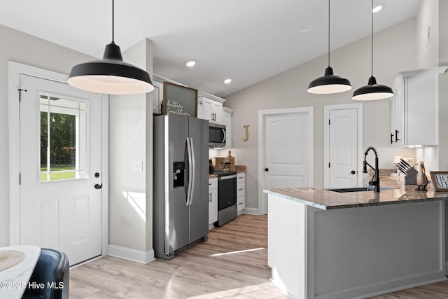 2665 Ash Little River Rd NW, Longwood, NC 28452 - kitchen featuring stainless steel appliances, a sink, vaulted ceiling, dark stone countertops, and light wood-style floors