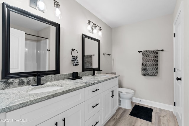 2665 Ash Little River Rd NW, Longwood, NC 28452 - full bath featuring wood finished floors, toilet, double vanity, baseboards, and a shower