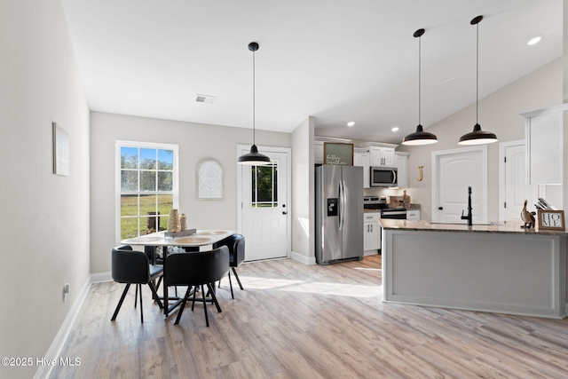 2665 Ash Little River Rd NW, Longwood, NC 28452 - kitchen featuring appliances with stainless steel finishes, light wood finished floors, baseboards, a sink, and white cabinetry