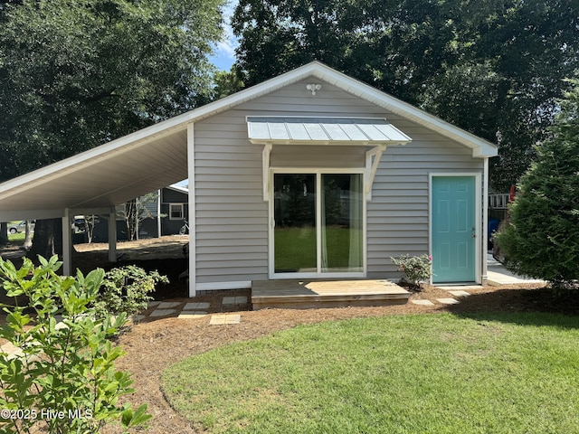 334 NE 48th St, Oak Island, NC 28465 - view of front facade featuring an outbuilding, a front lawn, and a standing seam roof