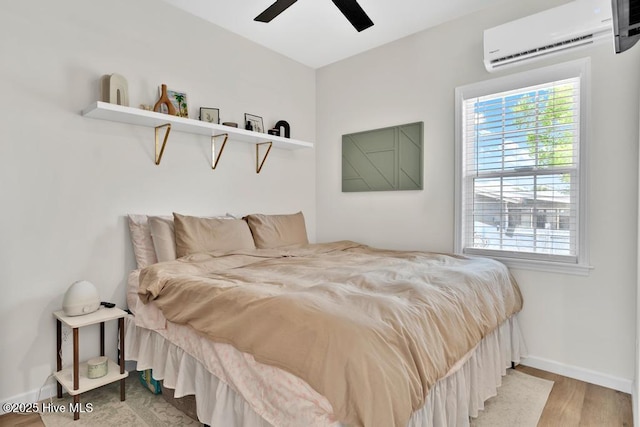 334 NE 48th St, Oak Island, NC 28465 - bedroom featuring a wall mounted air conditioner, multiple windows, wood finished floors, and baseboards