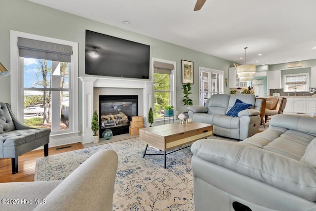 334 NE 48th St, Oak Island, NC 28465 - living room with ceiling fan, a fireplace with flush hearth, light wood finished floors, and recessed lighting