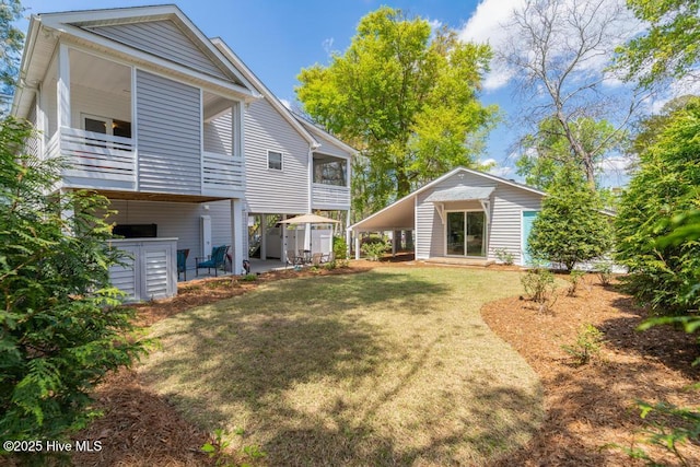 334 NE 48th St, Oak Island, NC 28465 - rear view of property with a yard, a patio area, and an outdoor structure