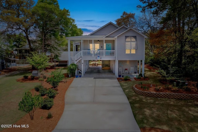 334 NE 48th St, Oak Island, NC 28465 - beach home featuring a porch, a carport, ceiling fan, concrete driveway, and stairway