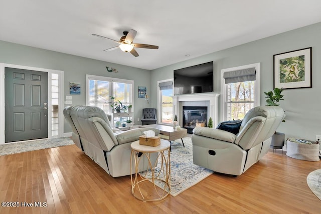 334 NE 48th St, Oak Island, NC 28465 - living area with light wood finished floors, plenty of natural light, ceiling fan, and a glass covered fireplace
