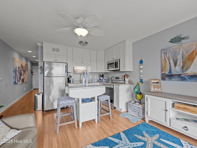 650 Cedar Point Blvd Unit B14, Cedar Point, NC 28584 - kitchen featuring visible vents, white cabinets, appliances with stainless steel finishes, a kitchen bar, and light wood-style flooring