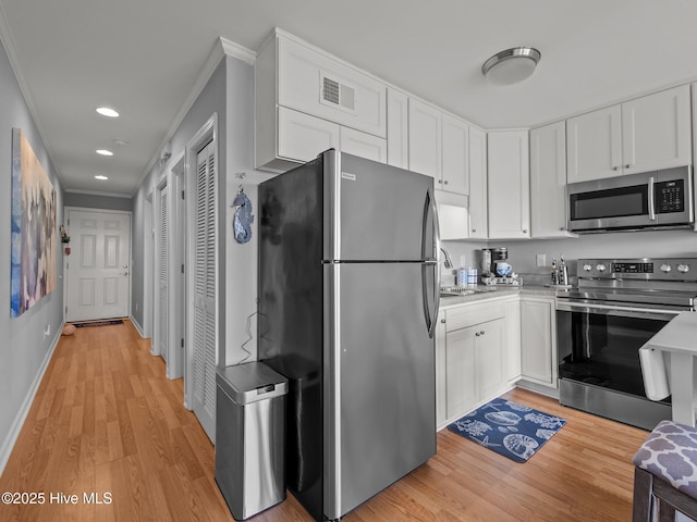 650 Cedar Point Blvd Unit B14, Cedar Point, NC 28584 - kitchen featuring ornamental molding, light countertops, light wood-style floors, visible vents, and appliances with stainless steel finishes