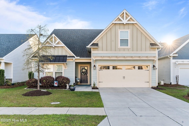 view of front of home with concrete driveway, board and batten siding, an attached garage, a front yard, and roof with shingles