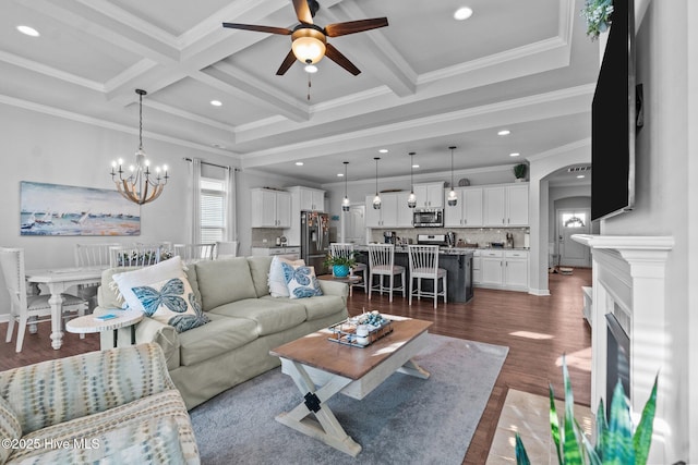 living area featuring arched walkways, crown molding, beamed ceiling, and ceiling fan with notable chandelier