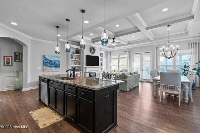 kitchen with a sink, dishwasher, arched walkways, a healthy amount of sunlight, and dark cabinets