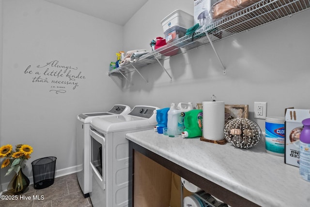 laundry area with baseboards, washer and dryer, and laundry area