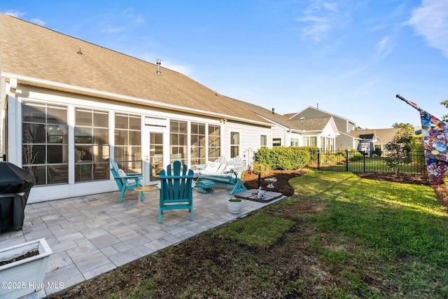 rear view of house with a lawn, a patio, fence, and roof with shingles