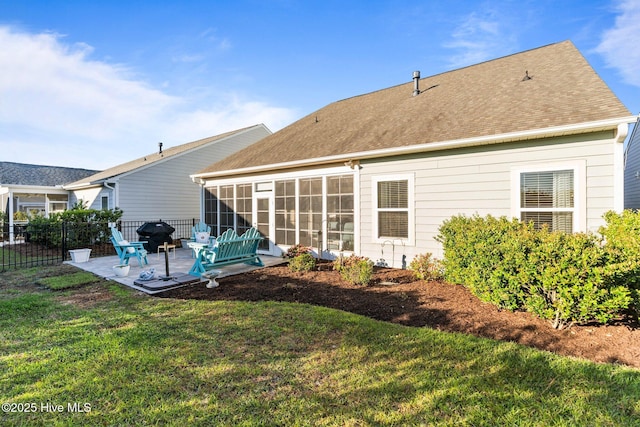 back of property featuring a patio area, fence, a yard, roof with shingles, and a sunroom