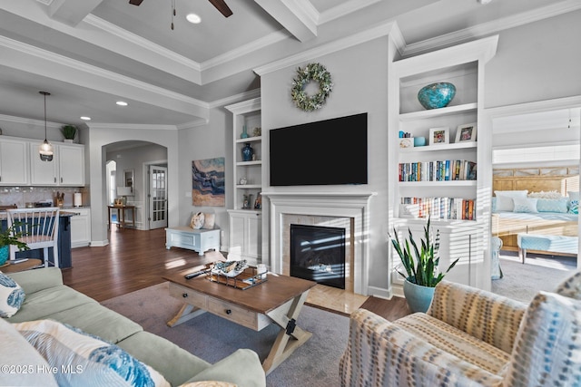 living area with arched walkways, recessed lighting, wood finished floors, ceiling fan, and ornamental molding