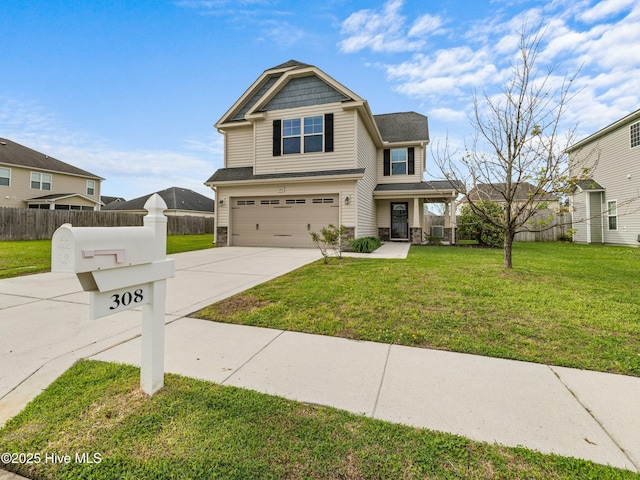 craftsman-style home featuring an attached garage, fence, driveway, and a front lawn