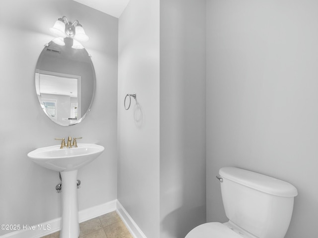 bathroom featuring toilet, baseboards, and tile patterned flooring