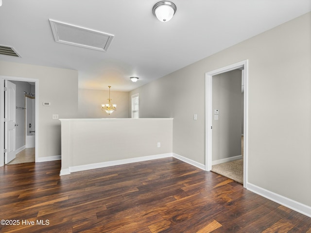 spare room featuring wood finished floors, baseboards, and visible vents