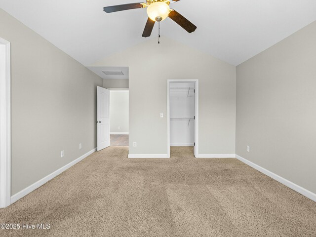 unfurnished bedroom featuring baseboards, light colored carpet, and vaulted ceiling
