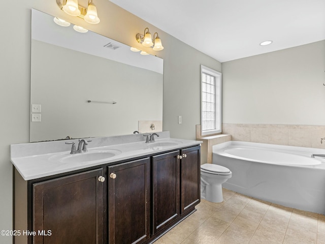 full bathroom with double vanity, a garden tub, visible vents, and a sink