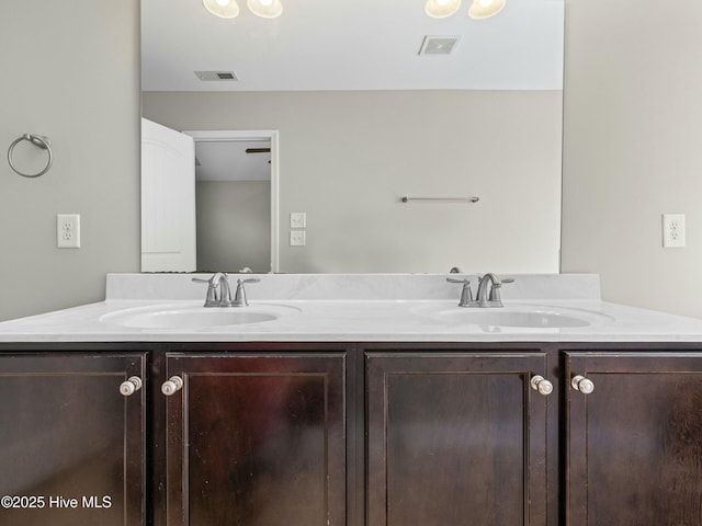 full bath featuring double vanity, a sink, and visible vents