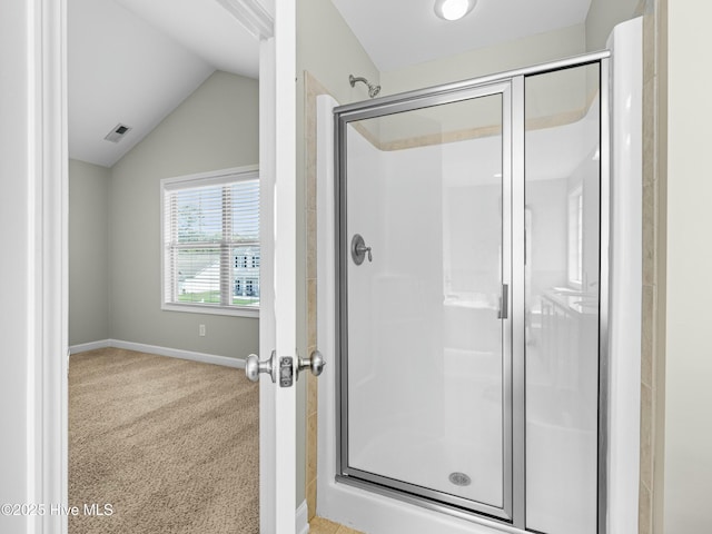 full bath featuring a stall shower, baseboards, vaulted ceiling, and visible vents