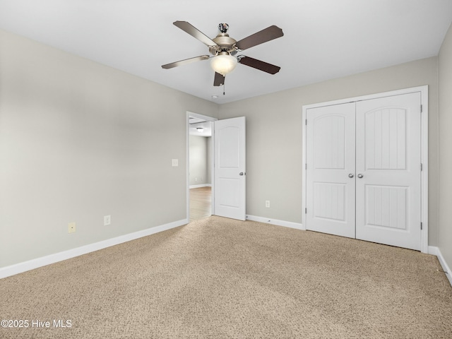 unfurnished bedroom with a closet, baseboards, a ceiling fan, and carpet floors