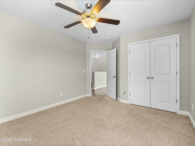 unfurnished bedroom with a closet, baseboards, a ceiling fan, and carpet