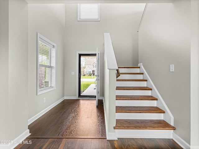 entrance foyer with baseboards, wood finished floors, and stairs