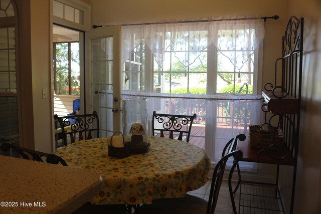 tiled dining room featuring french doors