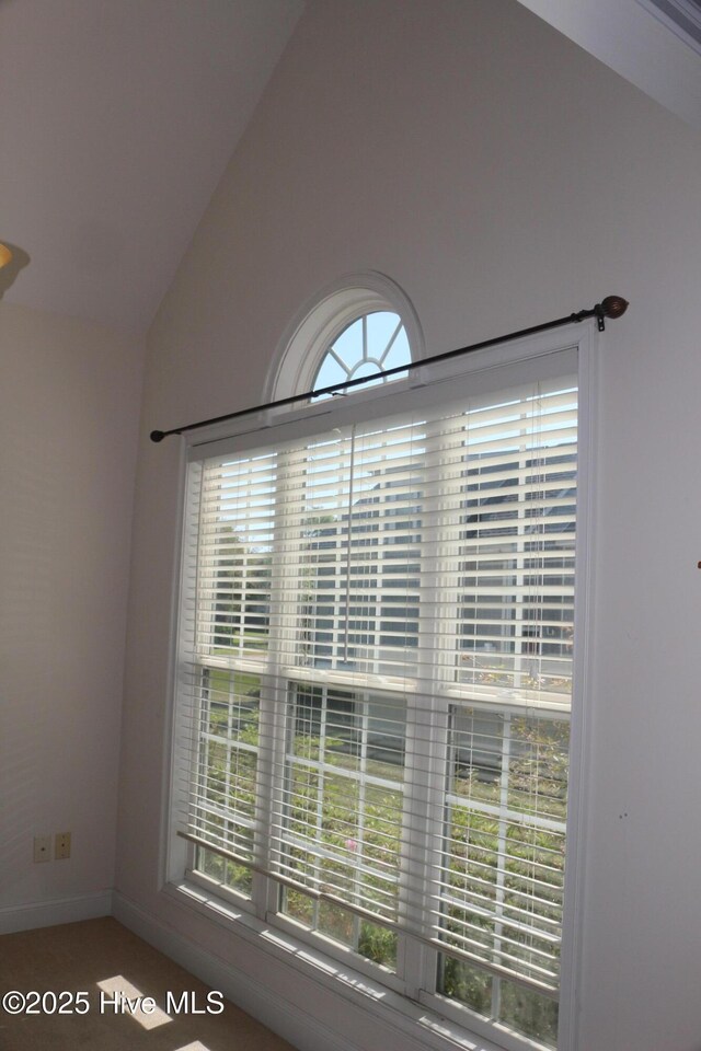 bedroom featuring ornamental molding, light carpet, ensuite bath, and multiple windows