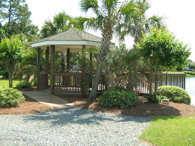 community pool featuring a water view, a patio area, and fence