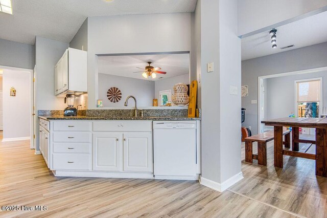 301 Softwood Ct, Jacksonville, NC 28540 - kitchen with dark stone countertops, white cabinets, white dishwasher, a sink, and a ceiling fan