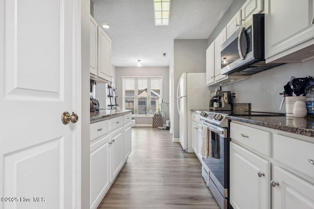 301 Softwood Ct, Jacksonville, NC 28540 - kitchen featuring baseboards, a textured ceiling, white cabinets, appliances with stainless steel finishes, and light wood finished floors