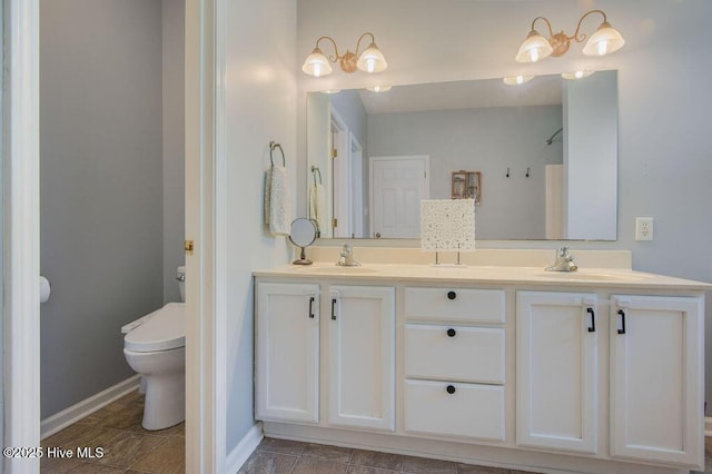 301 Softwood Ct, Jacksonville, NC 28540 - bathroom featuring double vanity, baseboards, a sink, and toilet