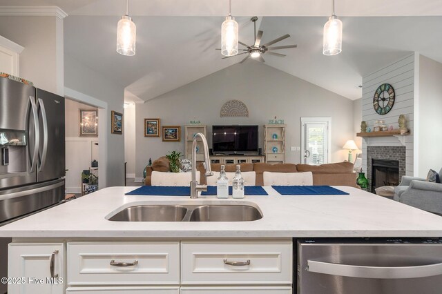 913 Wetherington Landing Rd, Stella, NC 28582 - kitchen with a brick fireplace, a sink, open floor plan, a ceiling fan, and stainless steel appliances