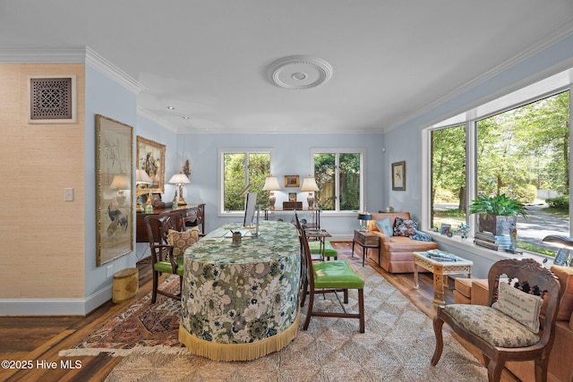 living area featuring crown molding, baseboards, wood finished floors, and visible vents
