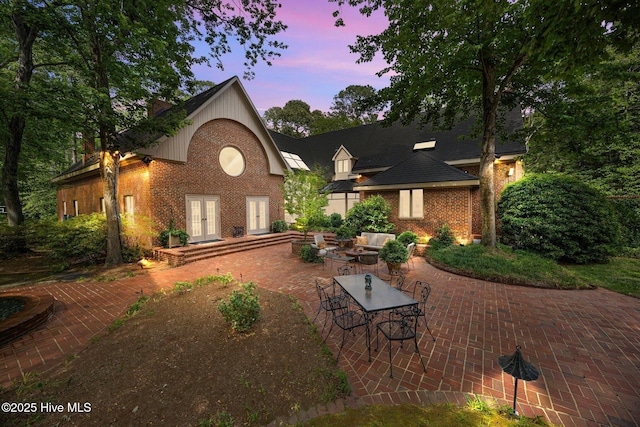 back of property with french doors, a patio area, and brick siding