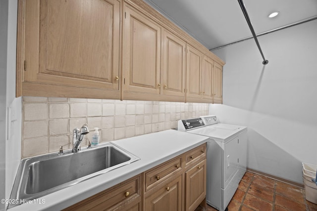 laundry room featuring a sink, baseboards, cabinet space, and washer and clothes dryer