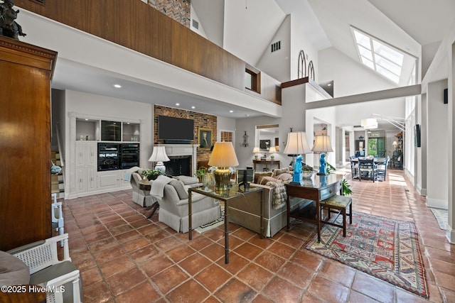 living room featuring visible vents, recessed lighting, a high ceiling, and a fireplace