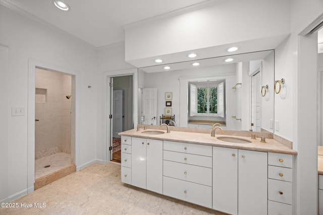 bathroom with a sink, a tile shower, recessed lighting, and double vanity