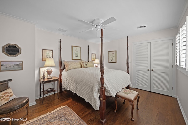 bedroom with baseboards, a closet, wood finished floors, and visible vents