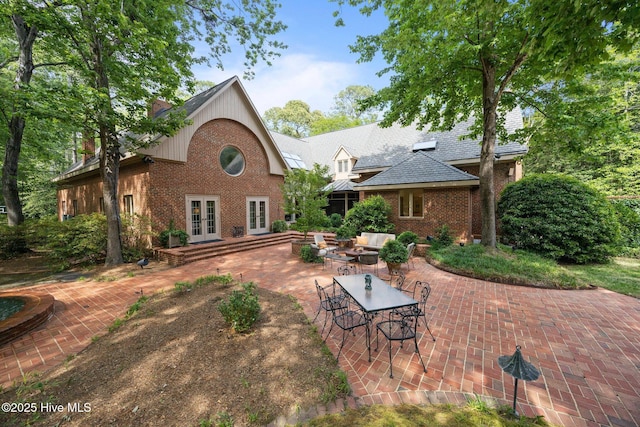 rear view of property featuring french doors, a patio area, and brick siding