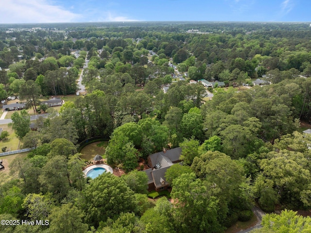 bird's eye view with a wooded view