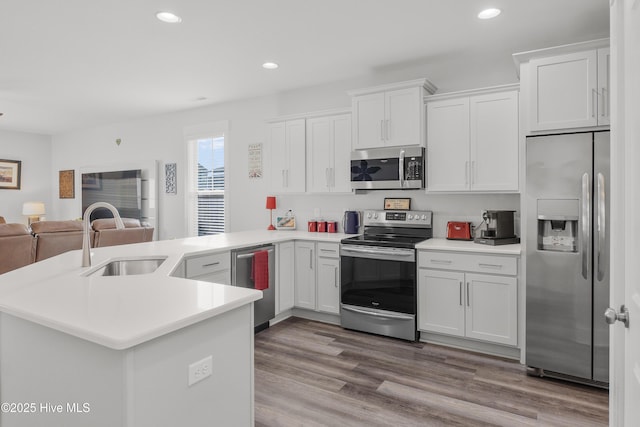 555 Heartwood Dr, Leland, NC 28479 - kitchen featuring stainless steel appliances, open floor plan, white cabinets, and a sink