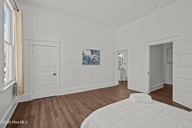bedroom with baseboards and wood finished floors