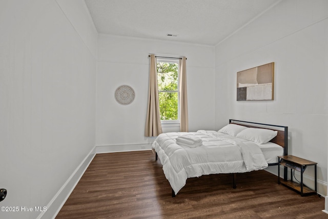 bedroom with baseboards and wood finished floors