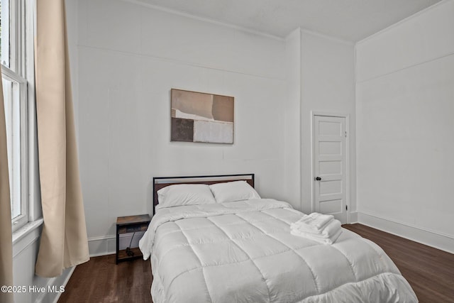bedroom featuring crown molding, wood finished floors, and baseboards