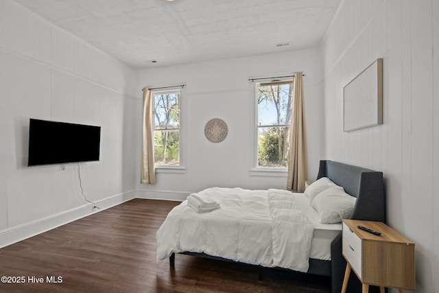 bedroom featuring dark wood-type flooring, visible vents, and baseboards