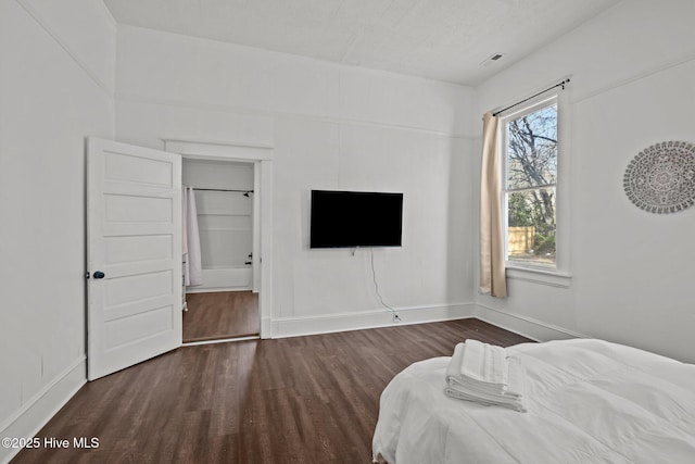 bedroom with baseboards and wood finished floors